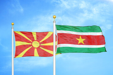 North Macedonia and Suriname two flags on flagpoles and blue sky