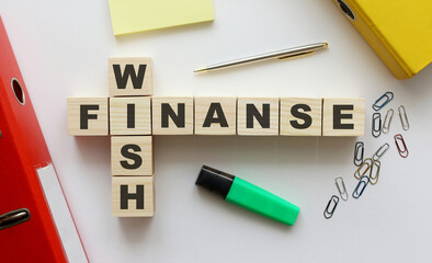 Wooden cubes with words WISH FINANCE on the office desk.