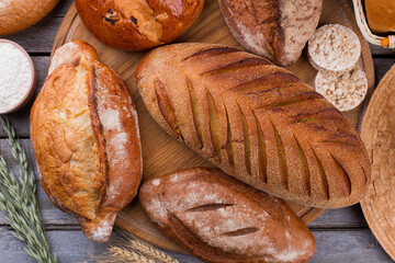 Crispy whole wheat bread background. Assortment of freshly baked homemade bread on wooden table. Bakery concept.