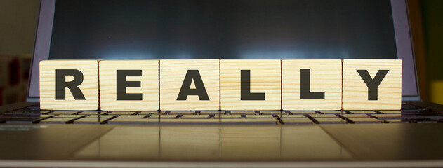 Obraz premium Wooden cubes with letters on a laptop keyboard.