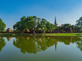 Fototapeta na wymiar タイ、アユタヤ遺跡群のワット・プラシーサンペットと池の水面のリフレクションと緑の木々 / Wat Pra Srisanpet with reflection on pond and green trees at Ayutthaya, Thailand