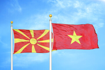 North Macedonia and Vietnam two flags on flagpoles and blue sky