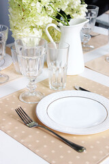 
festive table setting in orange. white plate with cutlery on the served table.