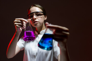 girl chemist in the laboratory conducts an experiment