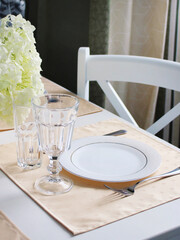 
festive table setting in orange. white plate with cutlery on the served table.