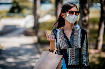 Woman wearing protective face mask and shopping bags