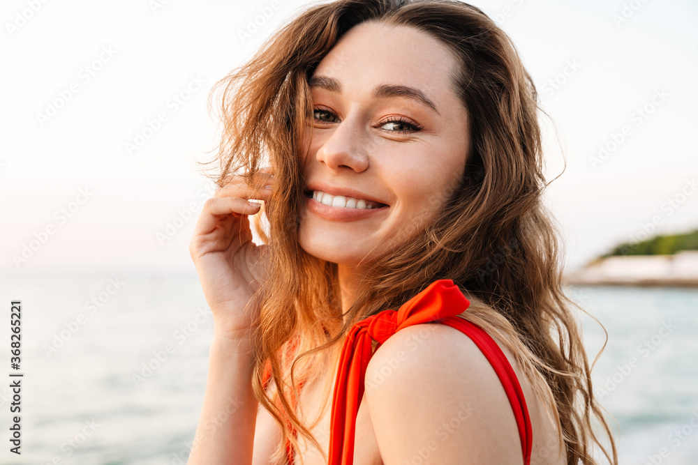 Wall mural Beautiful smiling young woman wearing bikini