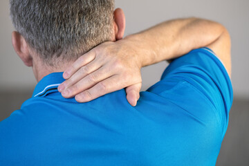 Pain in the neck, the man massages the place of inflammation with his hand.