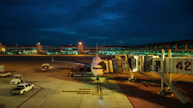 Time lapse ground staff Preparing the aircraft before flight Loading of baggage Food for flight services and equipment before boarding the airplane at night time, 4K 3840 x 2160 resolutions.