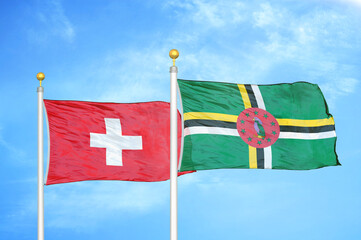 Switzerland and Dominica two flags on flagpoles and blue sky