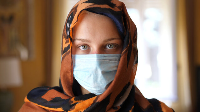 Caucasian Muslim Woman with a Surgical Mask Looking at Camera