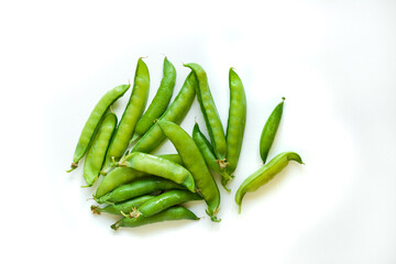A pile of raw green peas, fresh harvest from garden. Healthy vegetarian food concept, isolated on white background