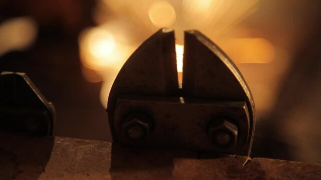 Filming of the welding process through equipment. In the foreground is an instrument, through it are golden brigs of metal. High quality FullHD footage