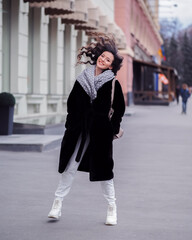 Brunette model makes funny dancing movement at the city