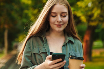 Smiling beautiful woman texting with her phone