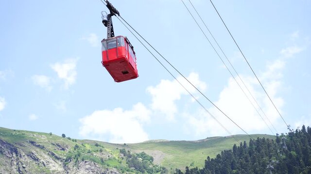 Close up of red funicular in sky. Old waggon moves along cable car in sunny weather.