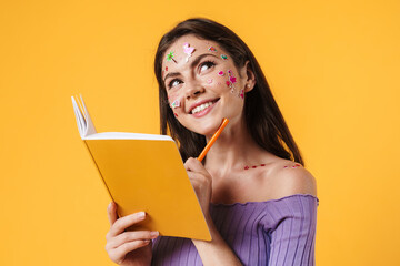 Image of young smiling woman writing in exercise book