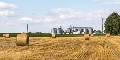 Modern Granary elevator. Silver silos on agro-processing and manufacturing plant for processing drying cleaning and storage of agricultural products, flour, cereals and grain.