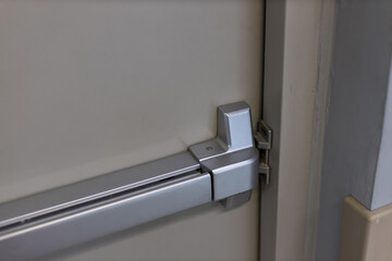 Emergency fire exit door. Closed up latch and rusty door handle of emergency exit. Push bar and...