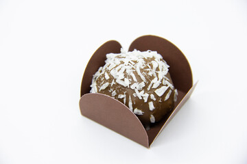 Chocolate bonbon with coconut shavings on white background