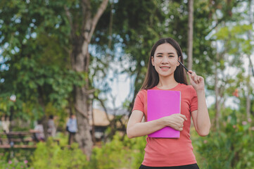 Young Asian Women holding book standing outdoor back to school,Concept back to school education study