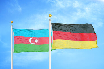 Azerbaijan and Germany two flags on flagpoles and blue sky
