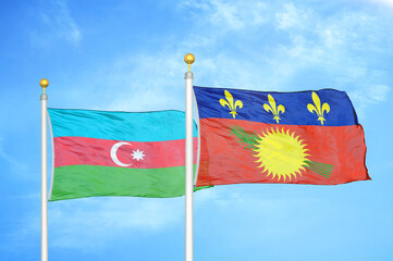 Azerbaijan and Guadeloupe two flags on flagpoles and blue sky