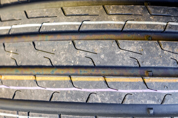 Focused on closeup of new car tires with tread marks for good traction. © Road Red Runner