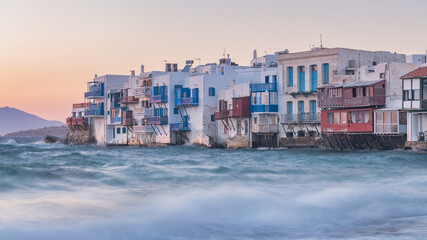 Fototapeta na wymiar The Little Venice district with old colorful houses by the sea in Mykonos Island at sunset, Cyclades, Greece. Greek landscape (100 matches). Travel and tourism concept.