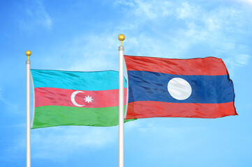 Azerbaijan and Laos two flags textile cloth. two flags on flagpoles and blue sky