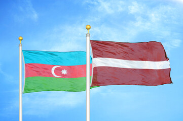 Azerbaijan and Latvia two flags on flagpoles and blue sky