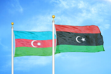 Azerbaijan and Libya two flags on flagpoles and blue sky
