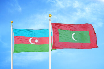 Azerbaijan and Maldives two flags on flagpoles and blue sky