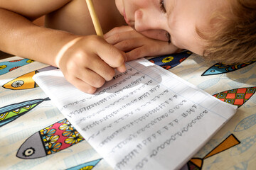 Boy tries to study and do his homework during the summer holidays.