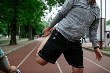 Young men exercising on a race track. Two young friends training outdoors..