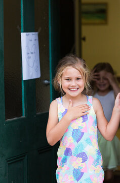 Six year old girl greeting at front door