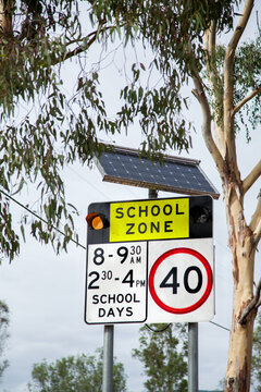 School zone warning sign with 40 km signal lights on the side of the road