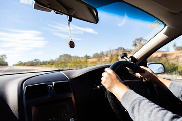 Person driving car on highway in daylight