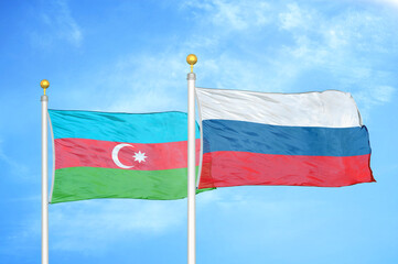 Azerbaijan and Russia two flags on flagpoles and blue sky
