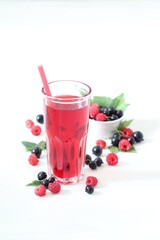 Berry drink, compote of fresh raspberries and black currants in a glass on a white background