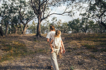 Father and daughter walking through bushland