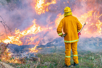 A fireman using a torch watching over a fuel reduction burn off