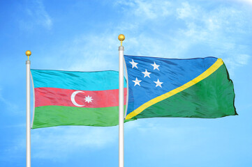 Azerbaijan and Solomon Islands two flags on flagpoles and blue sky