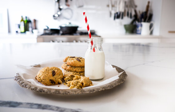 Fresh baked chocolate chip cookies and milk on the kitchen bench.