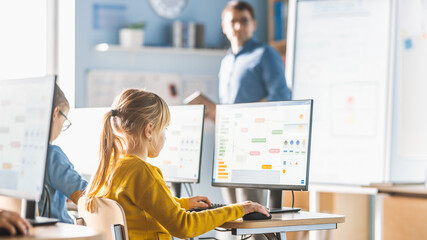 Elementary School Computer Science Classroom: Cute Little Girl Uses Personal Computer, Learning...