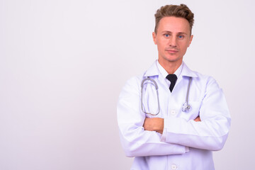 Fototapeta premium Handsome man doctor with blond curly hair against white background