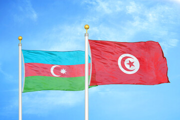 Azerbaijan and Tunisia two flags on flagpoles and blue sky