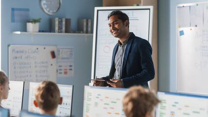 Elementary School Computer Science Class: Teacher Uses Digital Tablet, Explains Lesson to Diverse Group of Smart Children. Kids getting Modern Education, Learn Computer Science, Software Programming