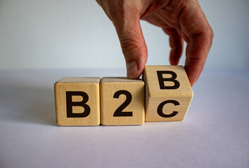 Business to Business or Busness to Consumer. Hand turns a cube and changes the expression 'B2B' to...