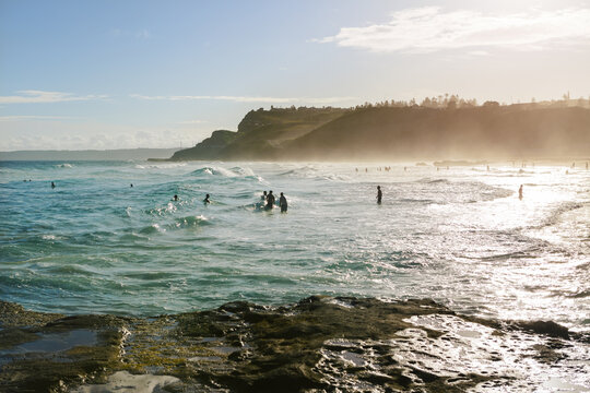 Newcastle beach late afternoon with sea mist in front of the cliff